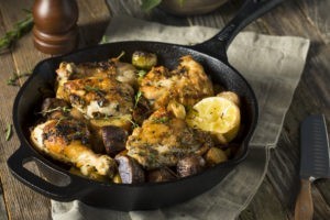 Baked chicken on skillet with lemon and herbs